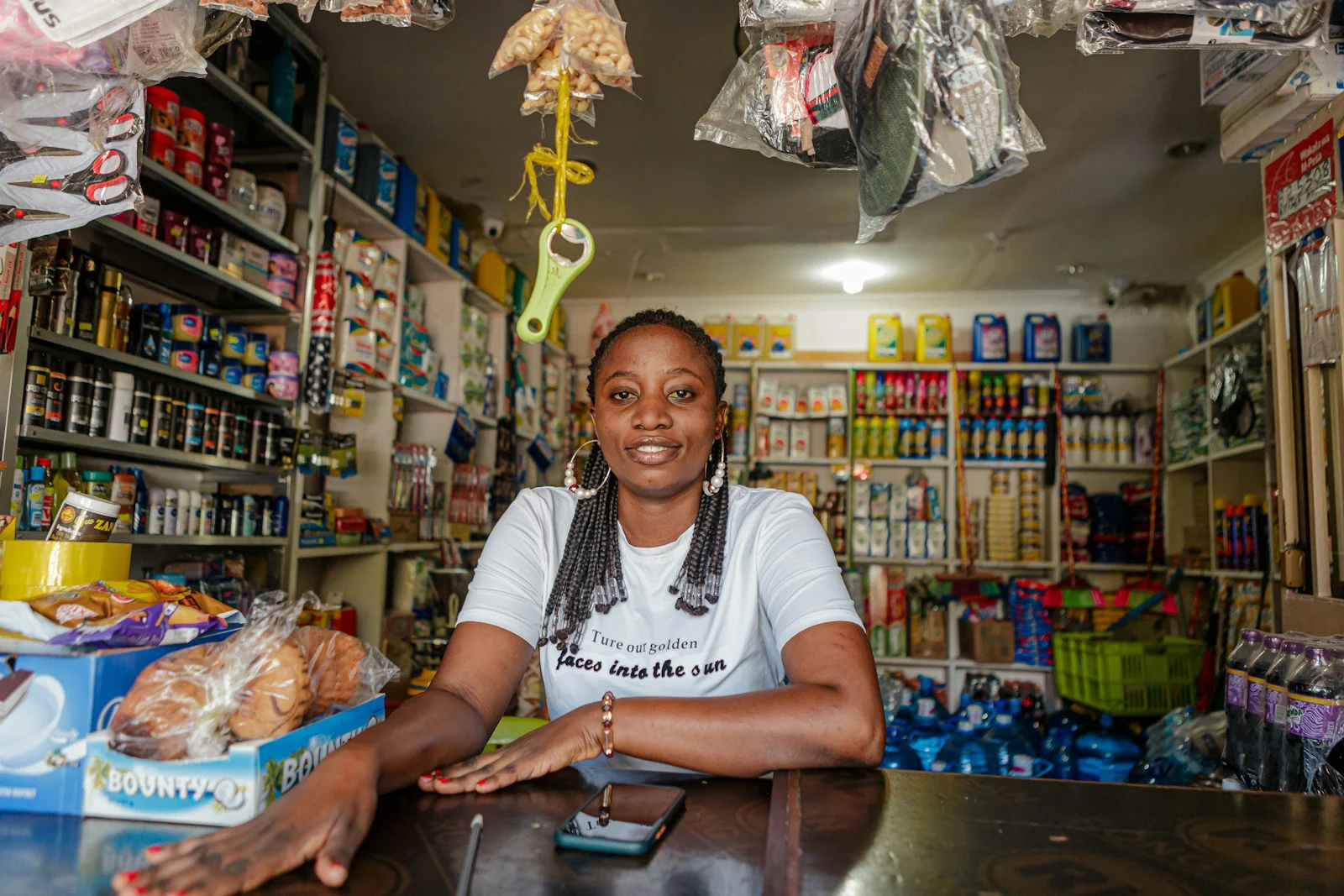 Smiling owner behind the counter of her small shop
